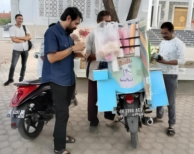 Gubernur Aceh Muzakir Manaf atau Mualem saat jajan ke pedagang pakai plat BK. (The Aceh Post)
